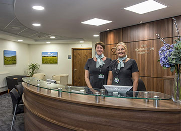 Our friendly team is there to support you through your recovery after female inguinal hernia treatment. This image shows two receptionists at the reception desk.