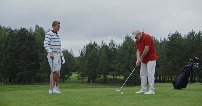 Two men playing golf. Patients typically return to golf after around 5-6 weeks, after plenty of hernia surgery recovery time!